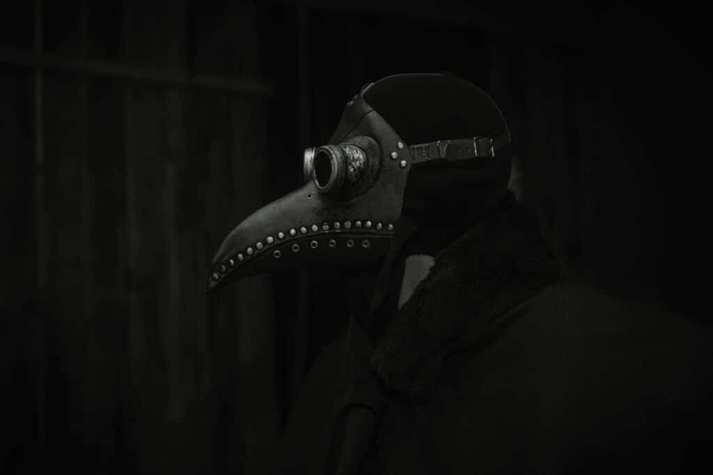 A haunting still life of a plague doctor mask in dark lighting, evoking historical and gothic themes.