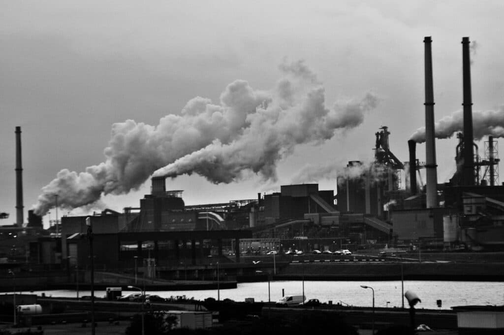 A black and white view of the industrial area in Rotterdam with smoke emissions.