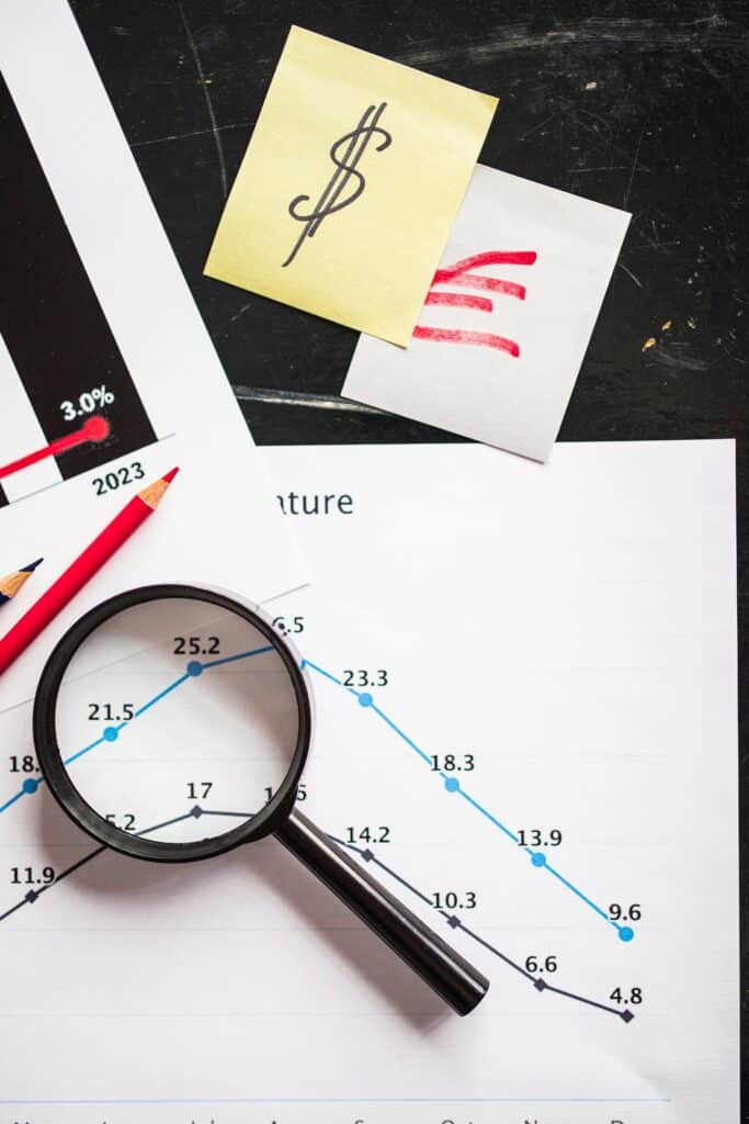 Top view of business documents with a graph, magnifying glass, and financial notes for detailed analysis.